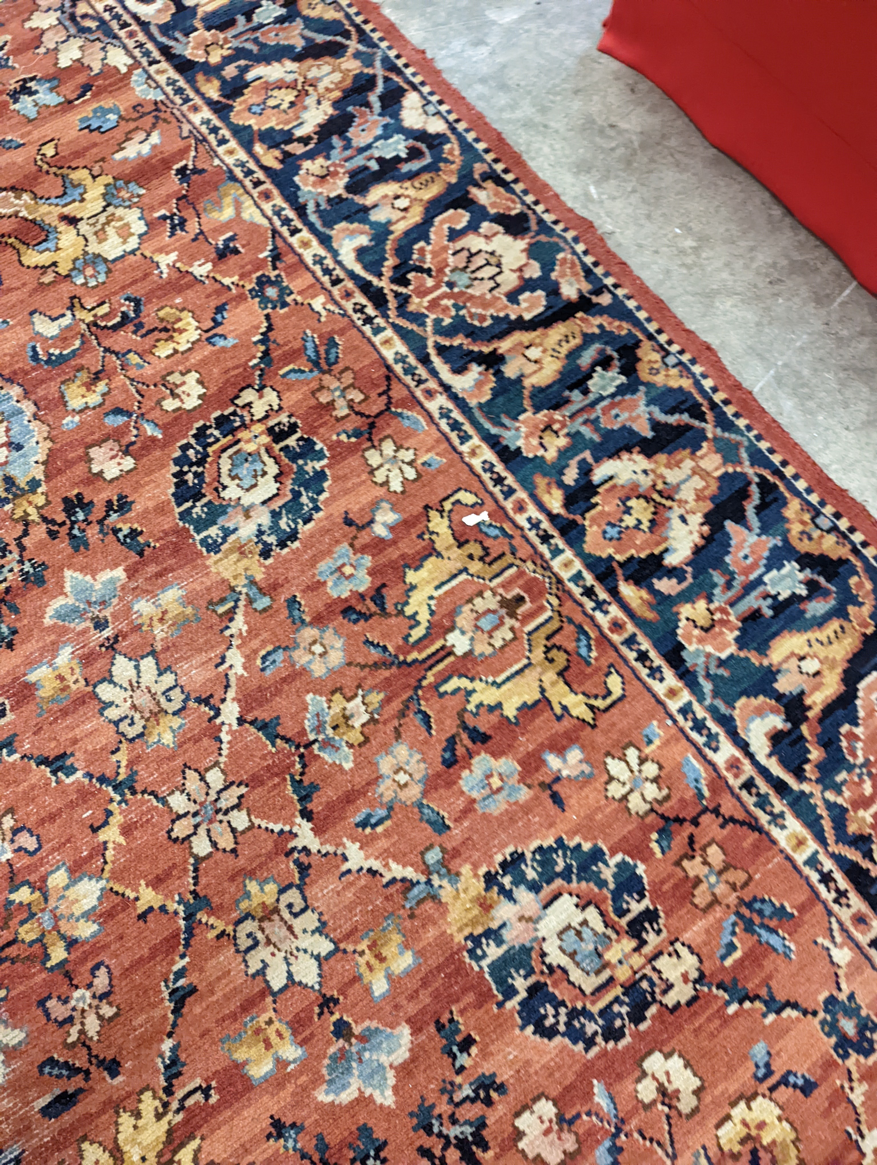A Persian style machined brick red ground carpet (severely worn), 392 x 286cm